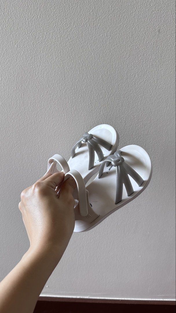 Mini Melissa White Silver Bow Jelly Sandals Size S (Category: Flats & Sandals) located in Taguig. Submitted by bpyte0408 (Listing ID 1463595020, Image 3). Description: Mini Melissa Sandals - Color: White with silver bow detail - Size: 10 USA / 27 EUR - Material: Jelly.