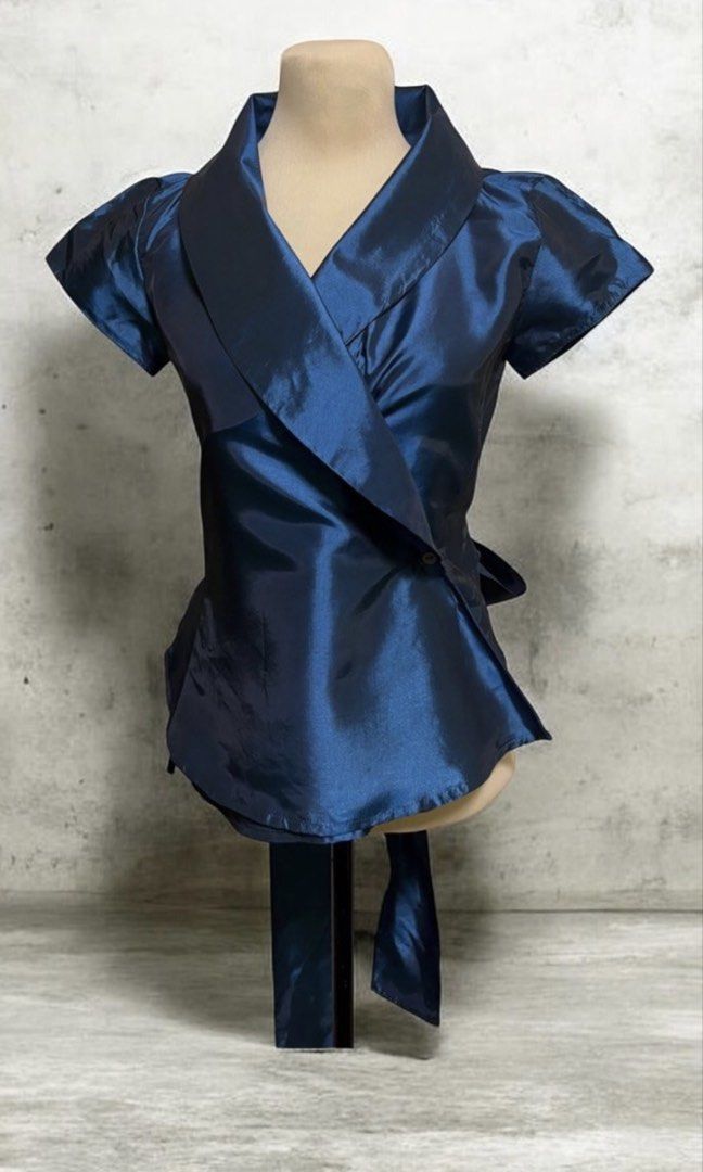 Minima Navy Blue Wrap Around Ribbon Blouse (Category: Blouses) located in Quezon City. Submitted by letsdeclutter101 (Listing ID 1463677431, Image 1). Description: - Elegant navy blue blouse - Flattering wrap-around ribbon tie - Short sleeves with a subtle puff detail - Fabric with a beautiful sheen - Bustline: 34 inches - Length: 21 inches.