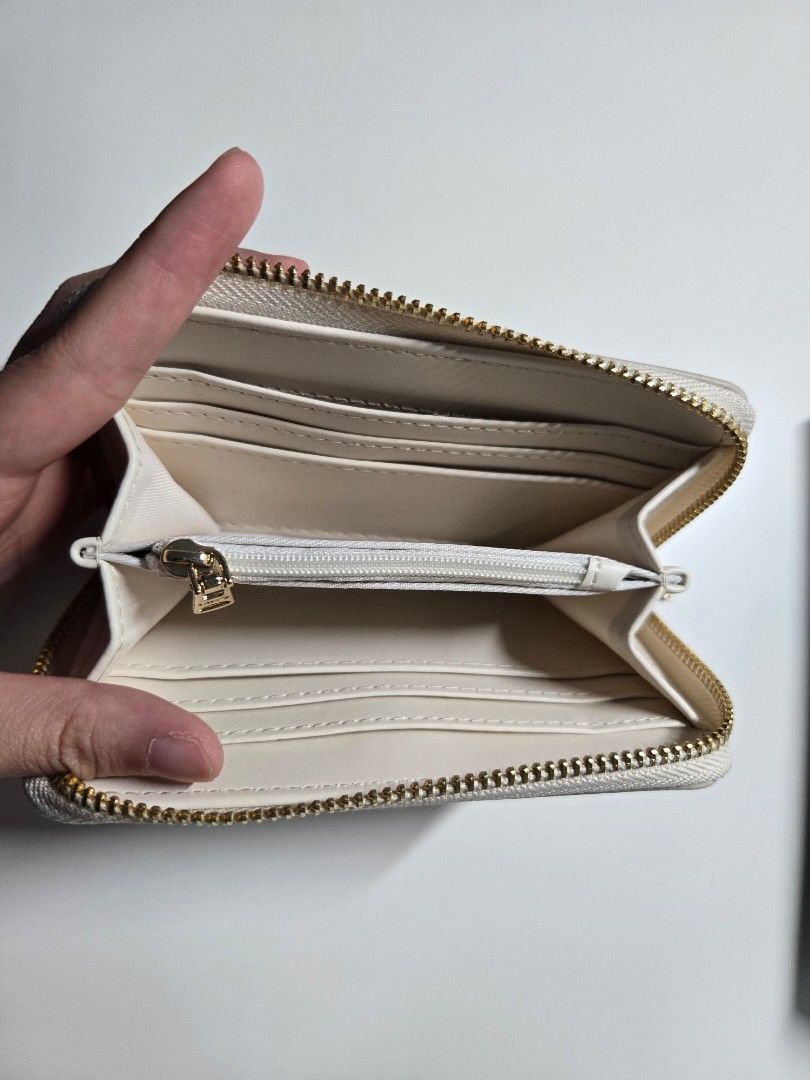 MNG Zip Around Wallet (Category: Wallets & Card holders) located in Cagayan de Oro. Submitted by itsnaja (Listing ID 1463691895, Image 2). Description: - White MNG wallet - Zip-around closure - Multiple card slots - Zippered compartment in the middle - Gold hardware - Clean interior - Great for organizing essentials.