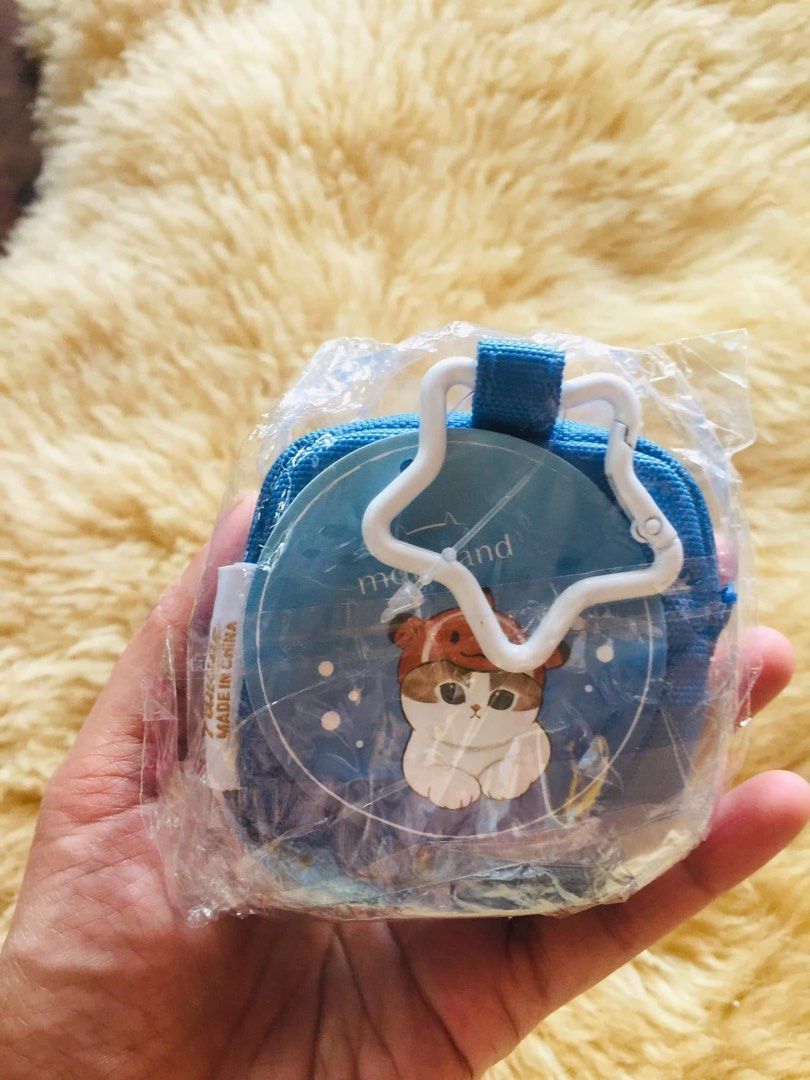 MOFUSAND embroided square mini pouch (Category: Purses & Pouches) located in Baguio. Submitted by izza_thrifty (Listing ID 1463571705, Image 3). Description: - Adorable blue coin pouch - Features a cute cat embroidery with a green hat - Secure zipper closure - Comes with a star-shaped keychain - Ideal for coins, small accessories, or earbuds - Compact and portable design - Brand: 'morijsand' - Origin: Made in China.