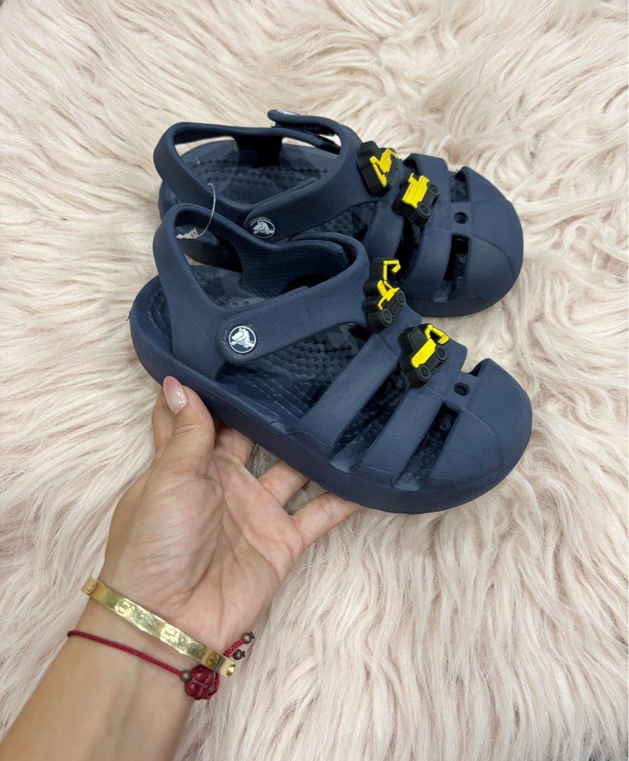 Navy Blue Crocs Sandals with Excavator Jibbitz (Category: Babies & Kids Fashion) located in Digos. Submitted by kathydiane76376 (Listing ID 1463695438, Image 3). Description: - Navy blue Crocs sandals for kids - Features fun yellow excavator Jibbitz on front straps - Easy velcro closure for a secure fit - Comfortable and durable material - Ideal for summer adventures and playtime - Perfect for little construction vehicle fans.
