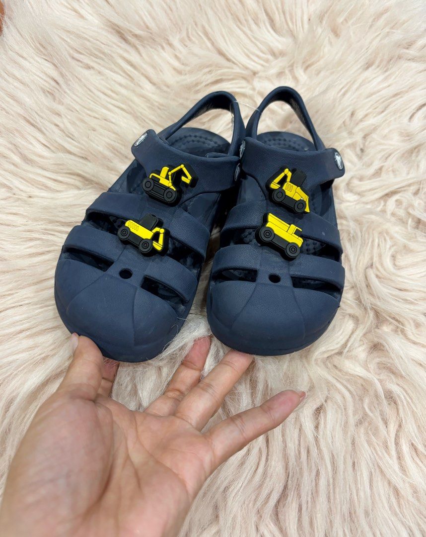 Navy Blue Crocs Sandals with Excavator Jibbitz (Category: Babies & Kids Fashion) located in Digos. Submitted by kathydiane76376 (Listing ID 1463695438, Image 1). Description: - Navy blue Crocs sandals for kids - Features fun yellow excavator Jibbitz on front straps - Easy velcro closure for a secure fit - Comfortable and durable material - Ideal for summer adventures and playtime - Perfect for little construction vehicle fans.