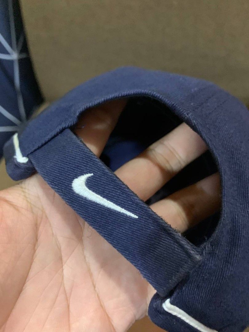 Navy Blue Nike Cap with White Trim (Category: Caps & Hats) located in Compostela. Submitted by francis_ace (Listing ID 1463663283, Image 3). Description: - Classic navy blue Nike cap - Embroidered 'NIKE' text and swoosh logo - White piping detail on brim - Adjustable strap for a custom fit - Ideal for everyday wear .