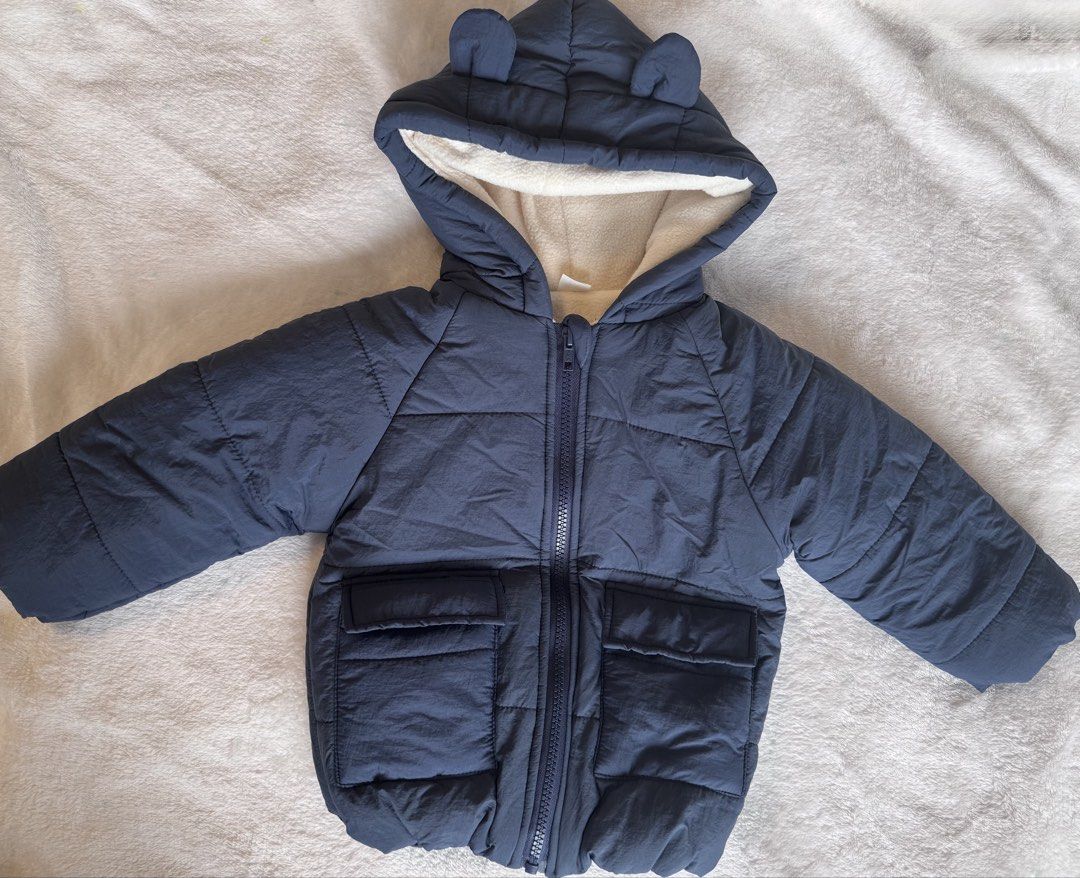 Navy Blue Puffer Jacket with Bear Ears Hood (Category: Babies & Kids Fashion) located in Quezon City. Submitted by issawoah (Listing ID 1463602656, Image 3). Description: - Adorable navy blue puffer jacket for kids - Cozy fleece lining inside the hood - Cute bear ears on the hood - Two functional front pockets - Easy zipper closure - Ideal for keeping warm on chilly days - 12 to 18 months on tag - Washed but never used.