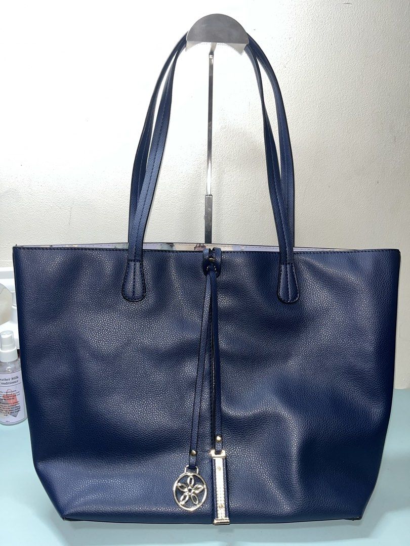 Navy Blue Reversible Tote Bag with Floral Interior (Category: Tote Bags) located in Liloan. Submitted by sakurumifinds2809 (Listing ID 1463721321, Image 1). Description: - Navy blue tote bag - Reversible with a pretty floral print lining - Open tote - Includes a decorative charm - Spacious interior for essentials - Comfortable shoulder straps - Perfect for everyday use or travel.