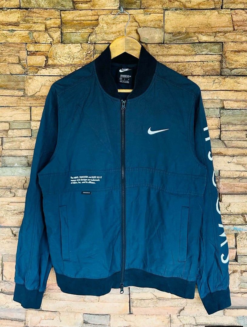 Nike Bomber Jacket Blue Swoosh Logo Size M (Category: Coats, Jackets and Outerwear) located in Santiago. Submitted by reyibanez253969 (Listing ID 1463632318, Image 1). Description: - Blue Nike Bomber Jacket - Size: Medium (M) - 21x26 - Iconic Swoosh logo on chest and sleeve - 'SWOOSH' text graphic down the sleeve - Standard fit - Made in Vietnam - Ideal for casual wear.