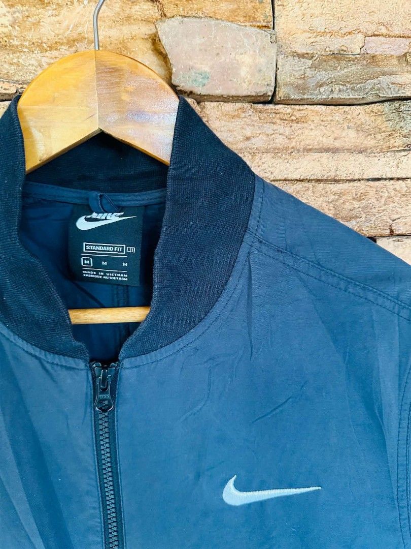 Nike Bomber Jacket Blue Swoosh Logo Size M (Category: Coats, Jackets and Outerwear) located in Santiago. Submitted by reyibanez253969 (Listing ID 1463632318, Image 3). Description: - Blue Nike Bomber Jacket - Size: Medium (M) - 21x26 - Iconic Swoosh logo on chest and sleeve - 'SWOOSH' text graphic down the sleeve - Standard fit - Made in Vietnam - Ideal for casual wear.