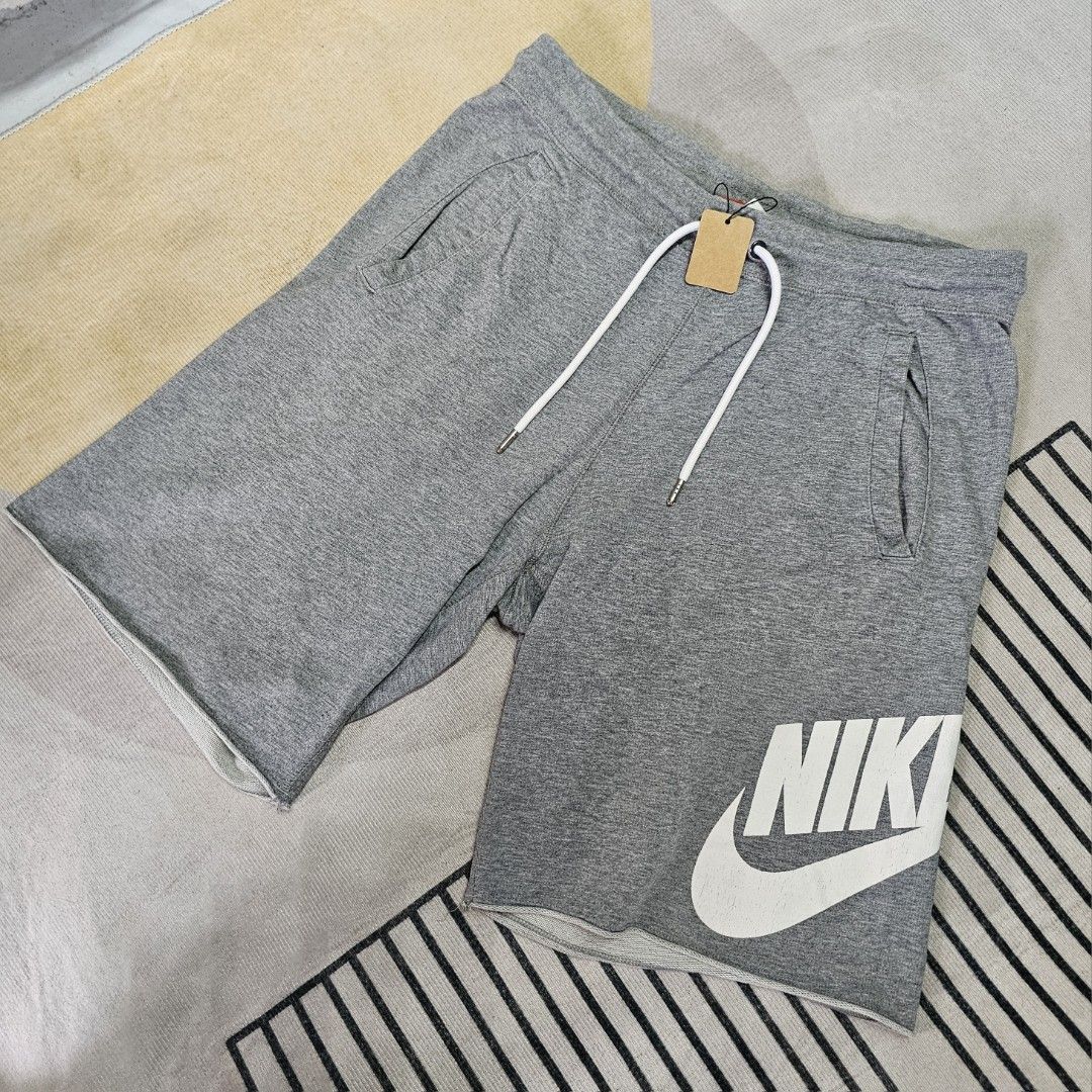 Nike Gray Shorts (Category: Shorts) located in Baguio. Submitted by kayeonlineshop (Listing ID 1463618193, Image 1). Description: grey Nike Club Alumni French Terry shorts featuring a prominent white logo on the left leg and an adjustable drawstring waistband w30-36 L19 h23.