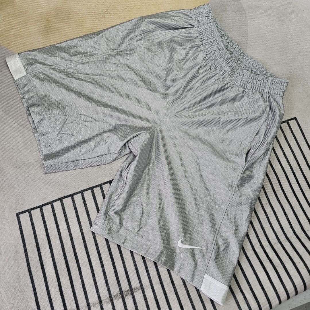 Nike Sport Shorts (Category: Shorts) located in Baguio. Submitted by kayeonlineshop (Listing ID 1463621150, Image 2). Description: silver-gray Nike shiny dazzle basketball shorts featuring a white Swoosh logo near the lower left hem. w26-34 L20 h24.