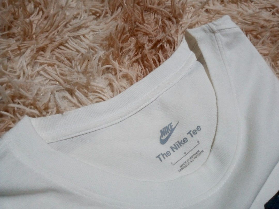 Nike White T-Shirt with Black Logo (Category: Activewear) located in Boston. Submitted by johnpaulvi30029 (Listing ID 1463681993, Image 3). Description: - Classic white Nike t-shirt - Features iconic black Nike logo and swoosh on the front - Made in Vietnam - Tag indicates size L - Simple and comfortable for everyday wear.