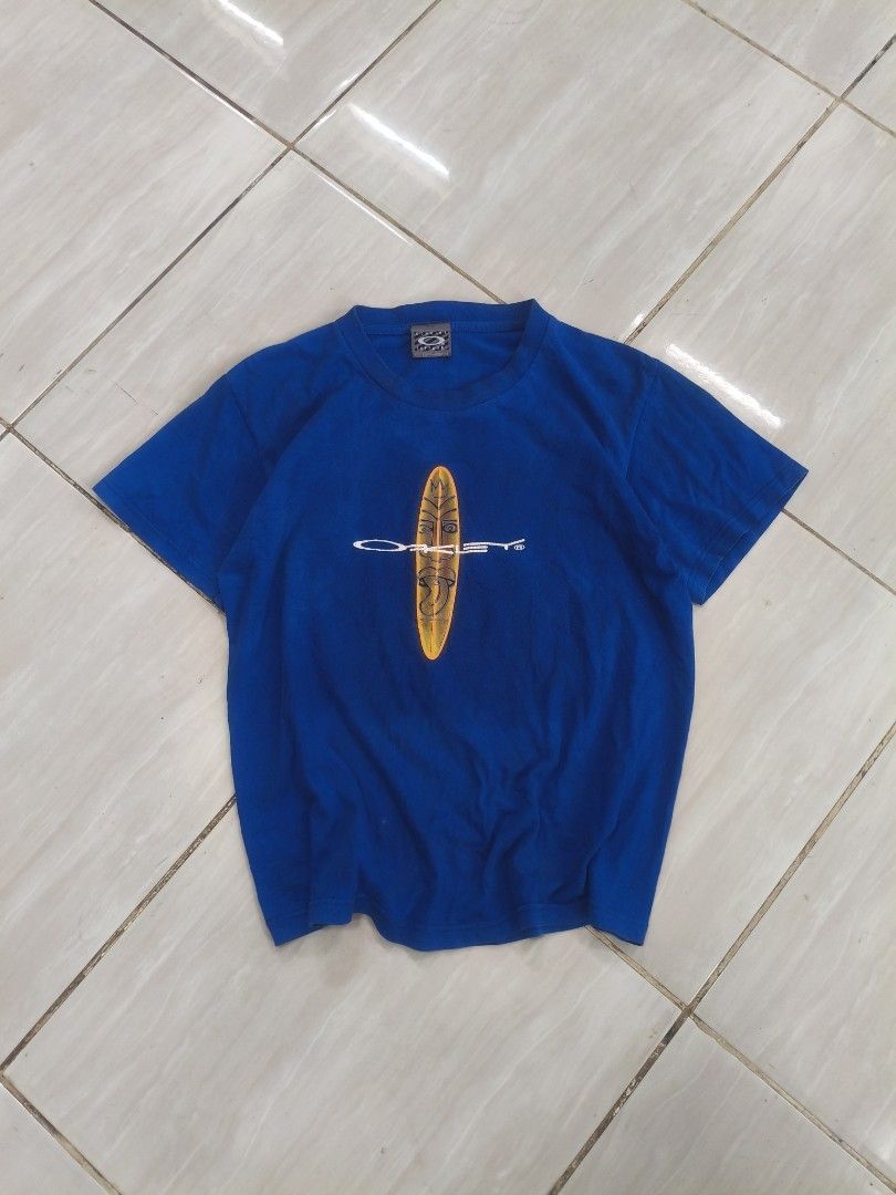 Oakley Blue T-shirt with Graphic Print (Category: Tshirts & Polo Shirts ) located in Manila. Submitted by boligaocyr23741 (Listing ID 1463600566, Image 1). Description: - Blue Oakley T-Shirt - Features a cool graphic print on the front - Made from 100% pre-shrunk cotton - Ideal for casual wear - Please check photos for detailed condition.