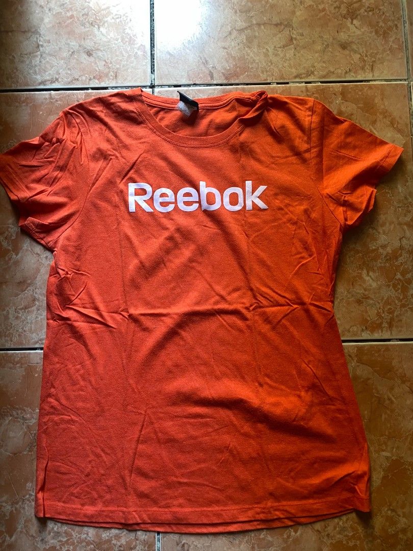 Orange Reebok T-shirt (Category: Shirts) located in Quezon City. Submitted by ben.cube (Listing ID 1463636607, Image 1). Description: - Bright orange Reebok t-shirt - Features classic Reebok logo on chest - Made from comfortable cotton material - Ideal for workouts or casual everyday wear - Simple, sporty, and versatile design.