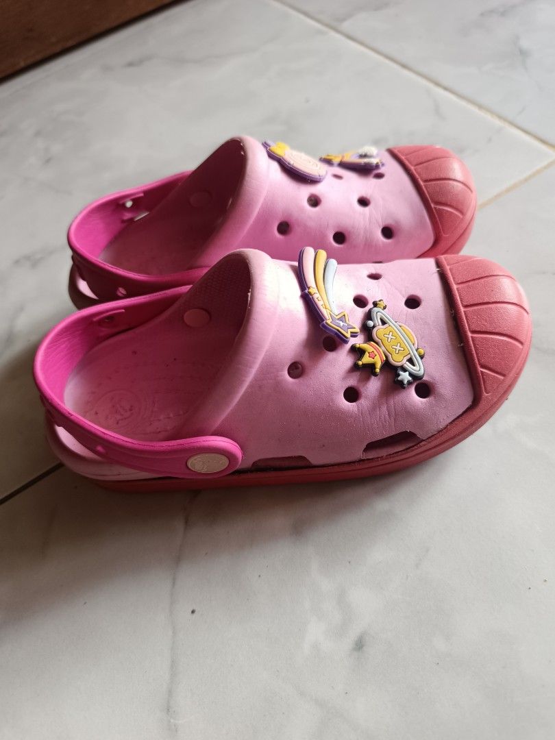 Pink Crocs with Charms for Kids (Category: Babies & Kids Fashion) located in Naga. Submitted by elzza_zenitram (Listing ID 1463594292, Image 3). Description: - Adorable pink Crocs for kids - Features fun charms: rainbows and planets - Easy slip-on and slip-off design - Durable soles with Crocs logo - Ideal for playtime and casual outings - Shows minor scuffs from normal use Size C 13 19cm insole Rfs: outgrown and declutter For pick-up and deliver