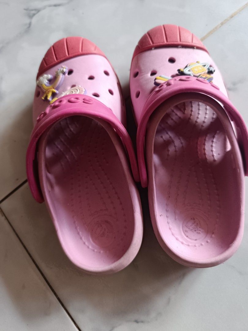 Pink Crocs with Charms for Kids (Category: Babies & Kids Fashion) located in Naga. Submitted by elzza_zenitram (Listing ID 1463594292, Image 2). Description: - Adorable pink Crocs for kids - Features fun charms: rainbows and planets - Easy slip-on and slip-off design - Durable soles with Crocs logo - Ideal for playtime and casual outings - Shows minor scuffs from normal use Size C 13 19cm insole Rfs: outgrown and declutter For pick-up and deliver