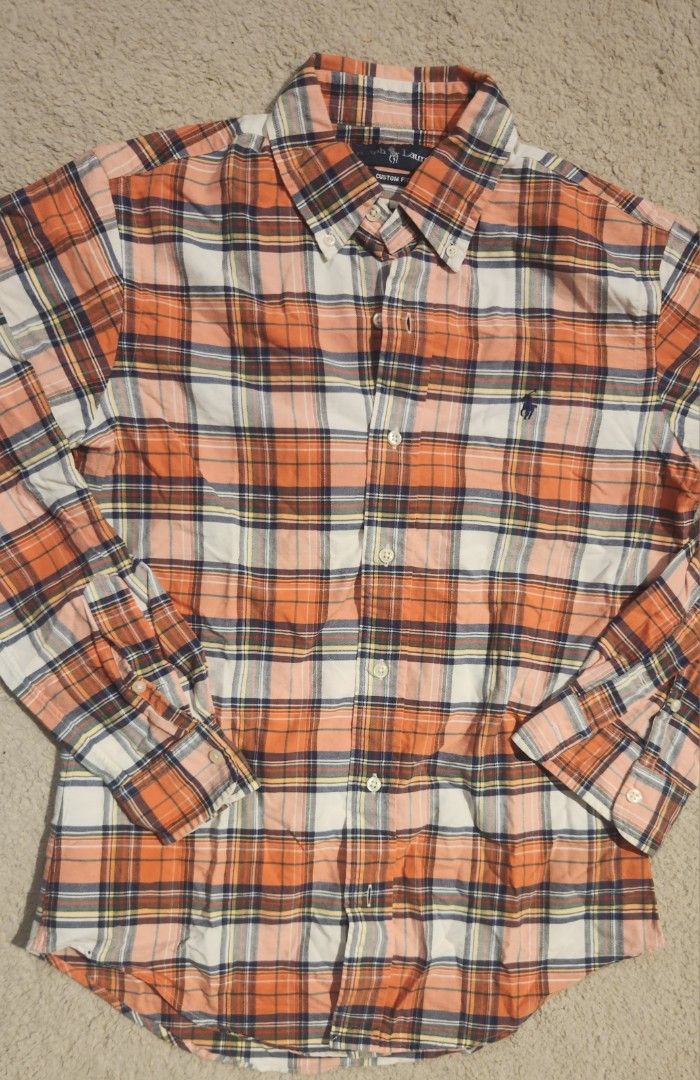Polo Ralph Lauren Plaid Button Down Shirt (Category: Tshirts & Polo Shirts ) located in Cabuyao City. Submitted by hd.mnnnnn (Listing ID 1463668892, Image 2). Description: 20x27 - Classic plaid button-down shirt by Polo Ralph Lauren - Signature pony logo embroidered on chest - Color: Orange, white, navy, and yellow plaid pattern - Button-up front and collar - Versatile for casual wear or layering.