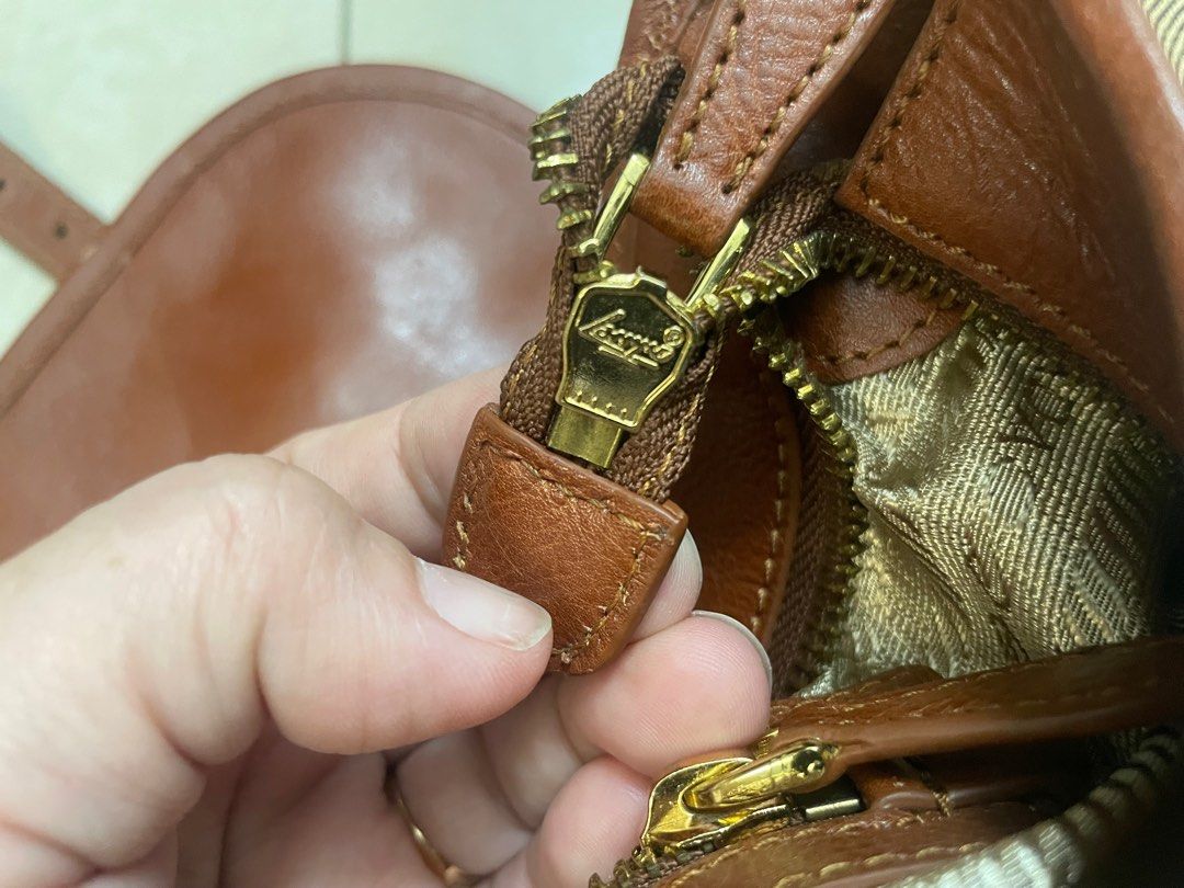 Prada Canvas Leather Shoulder Bag (Category: Luxury Bags & Wallets) located in Quezon City. Submitted by impulse.ph (Listing ID 1463664173, Image 3). Description: - Authentic Prada Bag - Color: Tan canvas with brown leather trim - Features: Adjustable shoulder strap, gold hardware - Interior: Zippered pockets and main compartment - Condition: Good, shows some signs of wear - Ideal for: Everyday use.