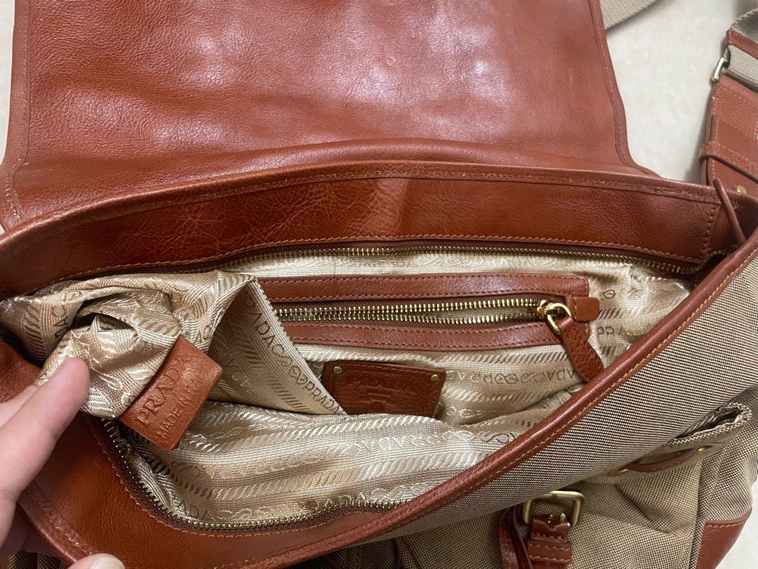 Prada Canvas Leather Shoulder Bag (Category: Luxury Bags & Wallets) located in Quezon City. Submitted by impulse.ph (Listing ID 1463664173, Image 2). Description: - Authentic Prada Bag - Color: Tan canvas with brown leather trim - Features: Adjustable shoulder strap, gold hardware - Interior: Zippered pockets and main compartment - Condition: Good, shows some signs of wear - Ideal for: Everyday use.