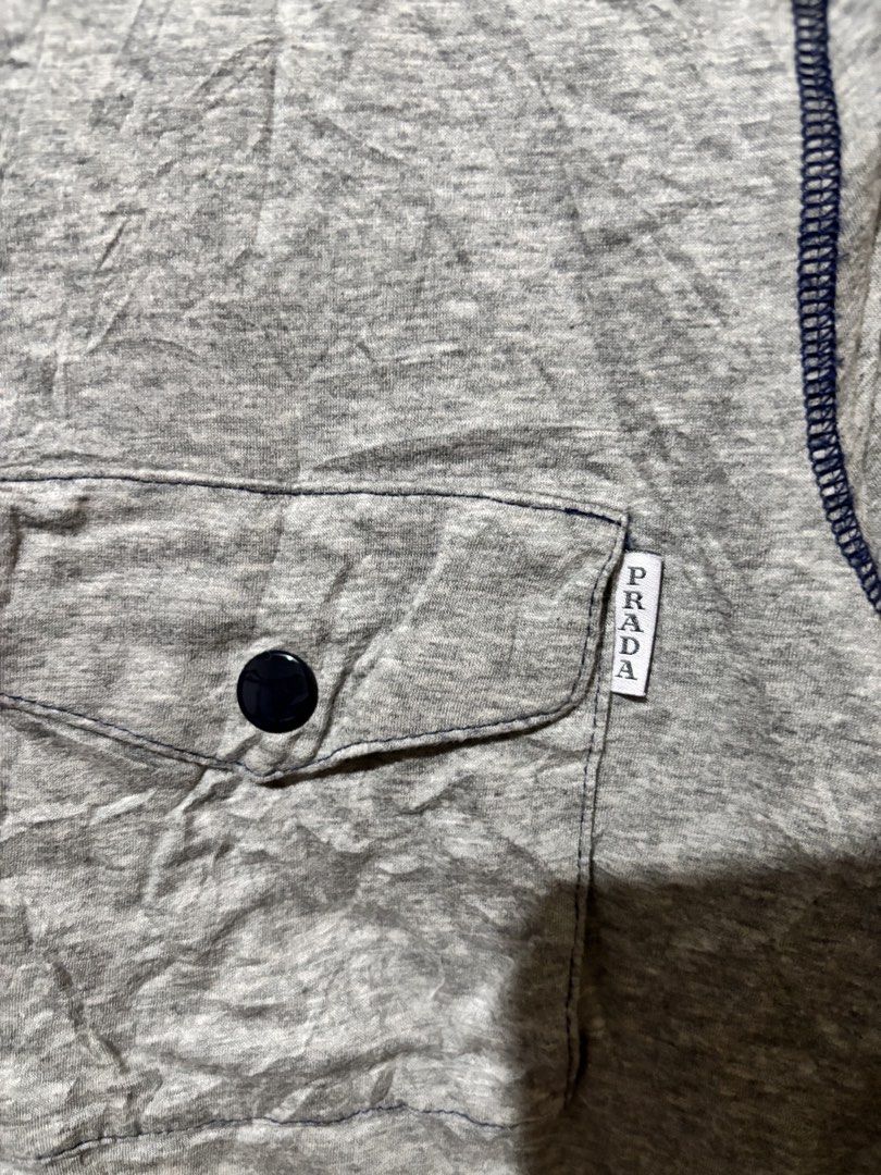 Prada Grey Pocket T-Shirt Size M (Category: Shirts) located in Lopez. Submitted by thrift.ni.roms22 (Listing ID 1463700833, Image 3). Description: - Grey Prada T-shirt - Size: Medium (M) - Features a classic chest pocket - Stylish contrast stitching detail - Ideal for everyday casual wear.