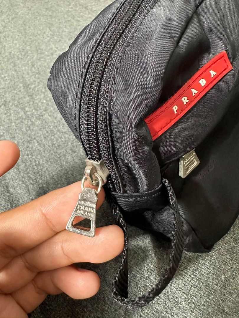 Prada Nylon Pouch Bag Black (Category: Luxury Bags & Wallets) located in Legazpi City. Submitted by rhumbalagu04057 (Listing ID 1463737571, Image 3). Description: - Authentic Prada pouch - Black nylon material - Front zip pocket - Main compartment - Interior with repeating Prada logo pattern - Branded 'Prada Milano' zipper pulls - Ideal for travel or everyday essentials.