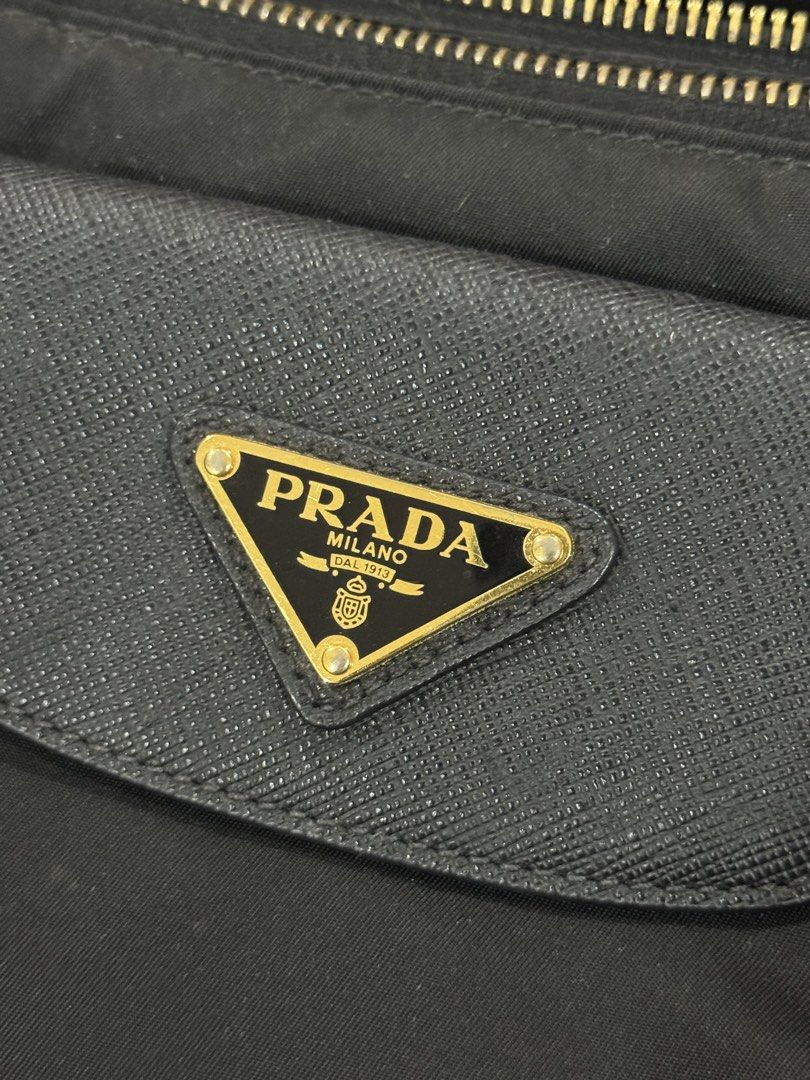 Prada Nylon Tessuto Tote Bag (Category: Luxury Bags & Wallets) located in Paranaque City. Submitted by nltnat (Listing ID 1463615361, Image 2). Description: - Authentic Prada Bag - Color: Black Nylon with Leather Trim - Hardware: Gold - Includes: Dust Bag and Authenticity Cards - Features: Spacious Interior, Top Zip Closure, Comfortable Top Handles - Style: Classic Prada Piece * with flaws sa handles, will give it to a lower price to a sure buyer