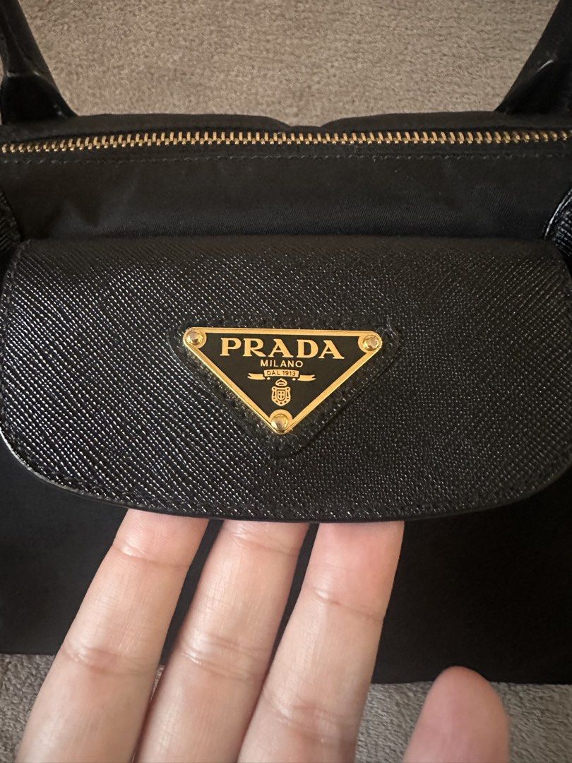 Prada Nylon Tessuto Tote Bag with Strap (Category: Luxury Bags & Wallets) located in Bacolod City. Submitted by katayellow (Listing ID 1463621829, Image 3). Description: - Authentic Black Prada Nylon Tote Bag - Saffiano Leather Trim & Handles - Gold-tone Hardware - Zipper Closure - Detachable Shoulder Strap Included - Four Protective Feet on Bottom - Ideal for Everyday Use ✅with Legitgrails .