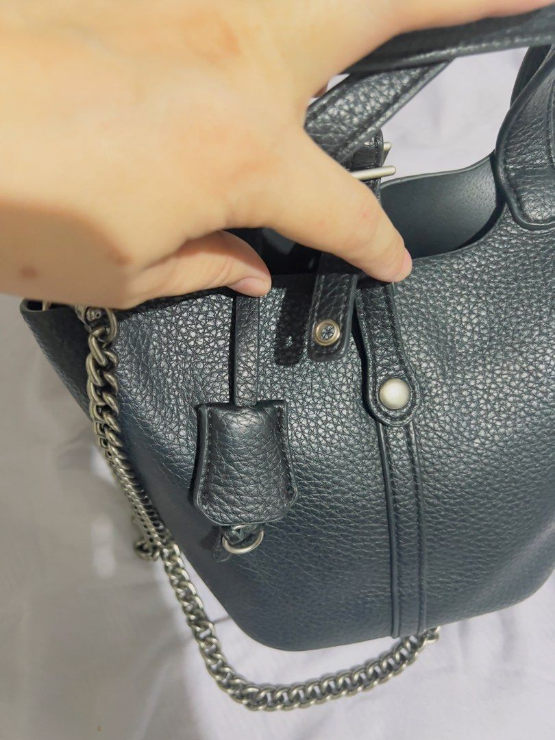Preloved Black Leather Bucket Bag with Chain Strap (Category: Shoulder Bags) located in Binan City. Submitted by unicohijoxfudge (Listing ID 1463653098, Image 2). Description: - Black pebbled leather bucket bag - Top handles - Detachable chain strap - Interior zippered pouch - Silver hardware details - Stylish everyday bag - Plenty of space for essentials Size: 9 x 7 inches height Delivery fee c/o buyer Tags: Burberry Calvin Klein Coach Michael K