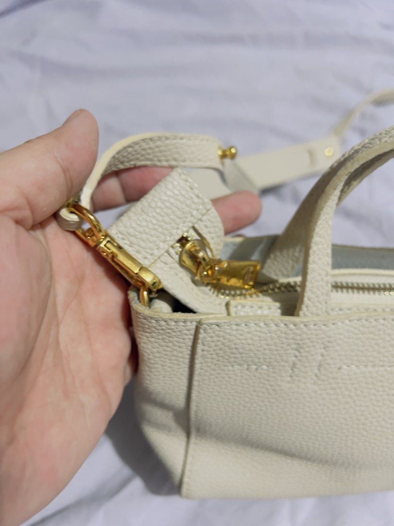Preloved Cream Textured Tote Bag with Shoulder Strap (Category: Tote Bags) located in Binan City. Submitted by unicohijoxfudge (Listing ID 1463654432, Image 3). Description: - Cream textured tote bag - Top handles and detachable shoulder strap - Zipper closure - Interior slip pocket - Gold hardware details - Versatile for everyday or night out Size: 7 x 4.5 onches height Delivery fee c/o buyer.