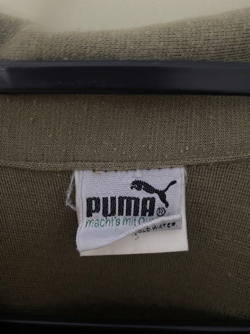 Puma Vintage Sweatshirt Khaki Green Collared Pullover (Category: Coats, Jackets and Outerwear) located in Malvar. Submitted by letharellano__71 (Listing ID 1463702795, Image 2). Description: - Vintage Puma sweatshirt - Khaki green color - Collared neckline with button closure - Elasticated cuffs and hem - Small embroidered Puma logo on right chest - Ideal for casual wear.