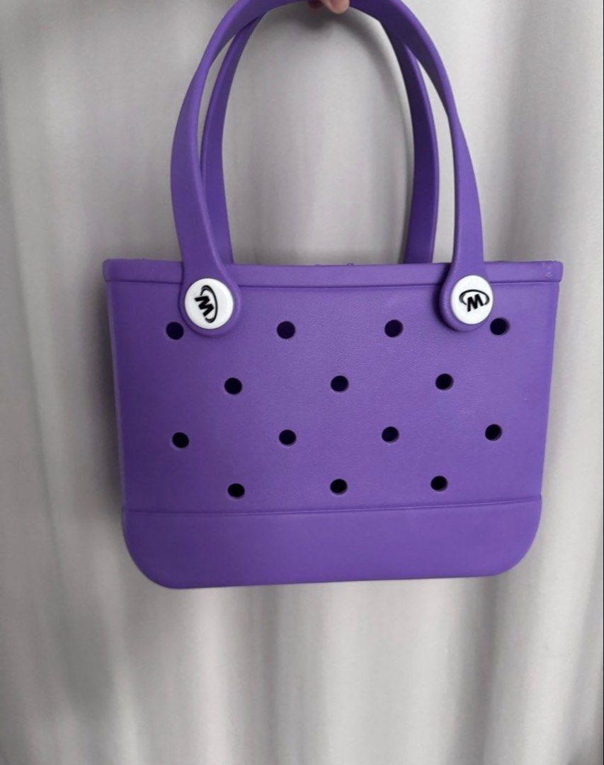 Purple Tote Bag with "M" Logo (Category: Tote Bags) located in Manila. Submitted by decluterthings888 (Listing ID 1463569369, Image 1). Description: - Cute purple tote bag - Features 'M' logo on the sides - Lots of holes for ventilation or adding charms - Perfect size for everyday use - Easy to clean material.
