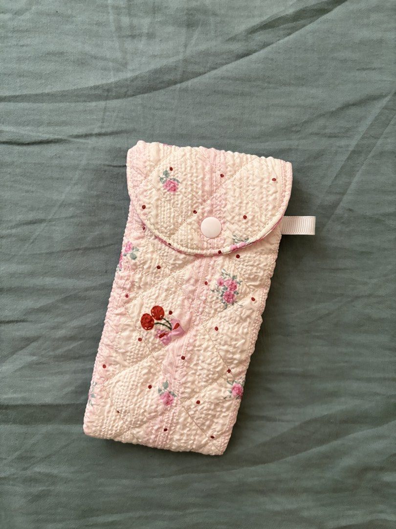 Quilted Pink Floral Pouch (Category: Purses & Pouches) located in Manila. Submitted by anabri (Listing ID 1463609556, Image 1). Description: - Adorable quilted pouch with a charming pink floral pattern. - Secure snap button closure to keep your items safe. - Lined with a sweet pink and white gingham fabric. - Features a delicate white ribbon loop on the side. - Ideal for organizing small essentials like glasses, pens, makeup, and more..