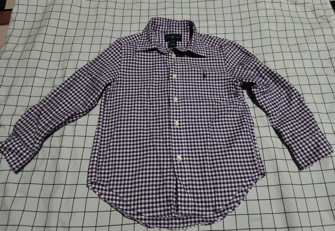 Ralph Lauren Gingham Button Down Shirt Size 4T (Category: Babies & Kids Fashion) located in Manila. Submitted by goeunlee (Listing ID 1463707991, Image 1). Description: - Brand: Ralph Lauren - Color: Purple and White Gingham - Style: Button-down shirt - Features: Classic embroidered pony logo on chest - Sleeves: Long sleeves with button cuffs - Size: 4T - Versatile: Perfect for casual wear or dressing up.