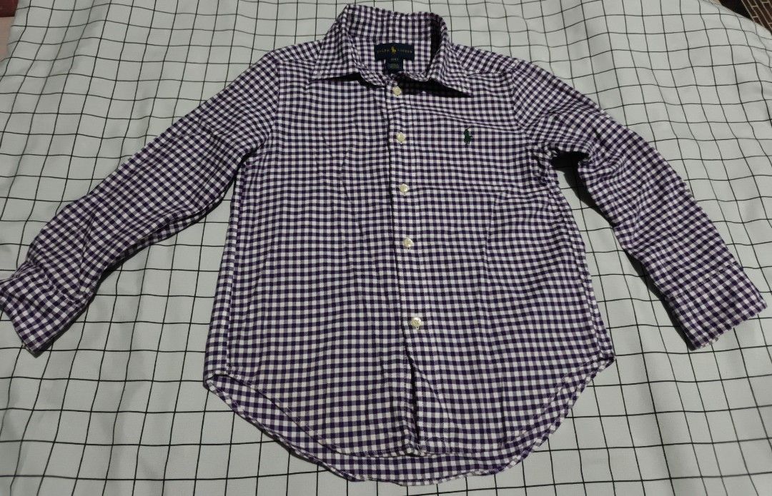 Ralph Lauren Gingham Button Down Shirt Size 4T (Category: Babies & Kids Fashion) located in Manila. Submitted by goeunlee (Listing ID 1463707991, Image 2). Description: - Brand: Ralph Lauren - Color: Purple and White Gingham - Style: Button-down shirt - Features: Classic embroidered pony logo on chest - Sleeves: Long sleeves with button cuffs - Size: 4T - Versatile: Perfect for casual wear or dressing up.