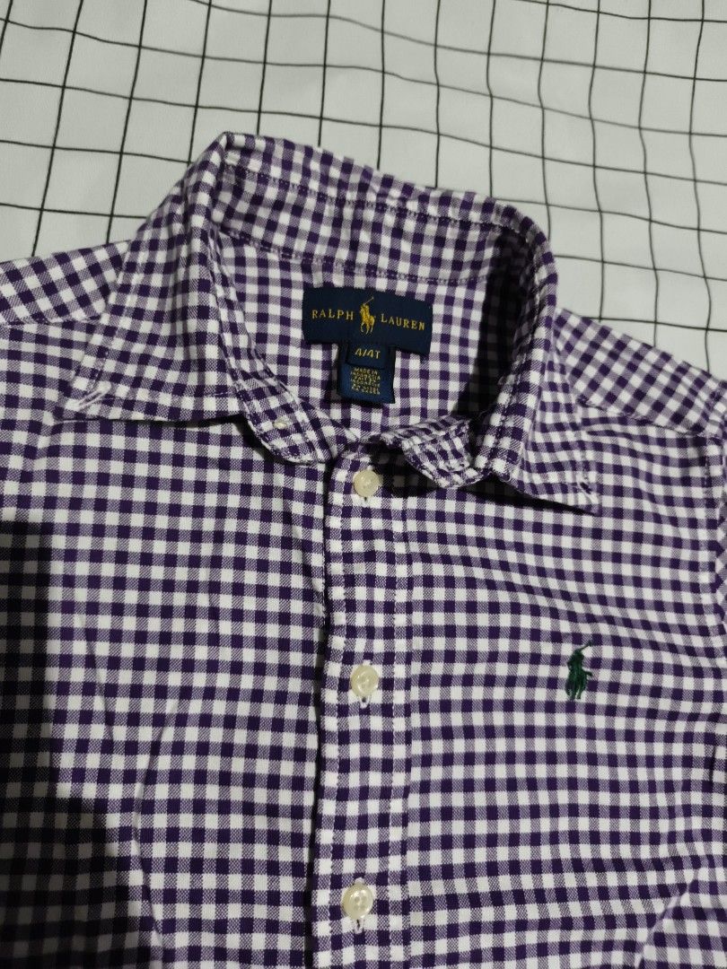 Ralph Lauren Gingham Button Down Shirt Size 4T (Category: Babies & Kids Fashion) located in Manila. Submitted by goeunlee (Listing ID 1463707991, Image 3). Description: - Brand: Ralph Lauren - Color: Purple and White Gingham - Style: Button-down shirt - Features: Classic embroidered pony logo on chest - Sleeves: Long sleeves with button cuffs - Size: 4T - Versatile: Perfect for casual wear or dressing up.