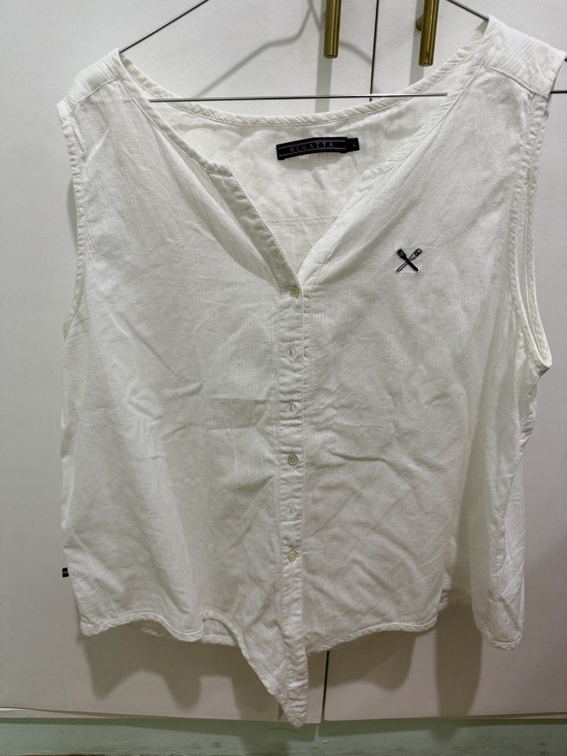Regatta White Sleeveless V-Neck Button-Up Top (Category: Sleeveless) located in Quezon City. Submitted by pamelasal51714 (Listing ID 1463575412, Image 1). Description: - Brand: Regatta - Style: Sleeveless V-neck top - Features: Button-up front, embroidered logo on chest - Design: Lightweight fabric with subtle vertical stripes - Occasion: Ideal for casual wear or layering.