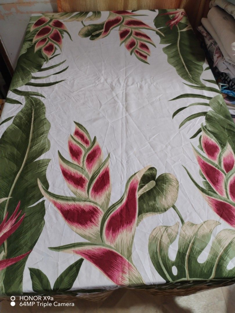 Round Table Topper w/ washable stain (Category: Table Linen & Textiles) located in Muntinlupa City. Submitted by arciagamaryann68 (Listing ID 1463603888, Image 2). Description: - Round table topper with a beautiful tropical design. - Features vibrant pink heliconia flowers and lush green leaves. - Washable and stain-resistant material for easy cleaning. - Adds a touch of paradise to your home decor. - Minor, washable stains are present but not ve