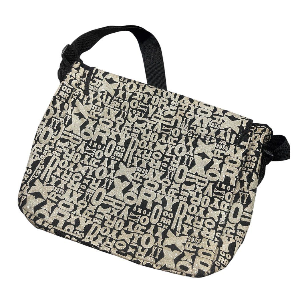 Roxy Messenger Bag - All Over Logo Print Authentic (Category: Shoulder Bags) located in San Pedro. Submitted by lifebeginsaftercoff33 (Listing ID 1463662985, Image 3). Description: This is a vintage Y2K Roxy messenger bag featuring an all-over typographic logo print and a striking teal mountain logo on the front flap -Cool Roxy messenger bag - water resist - Black and white all-over logo print - Blue Roxy heart logo on front flap - Adjustable str