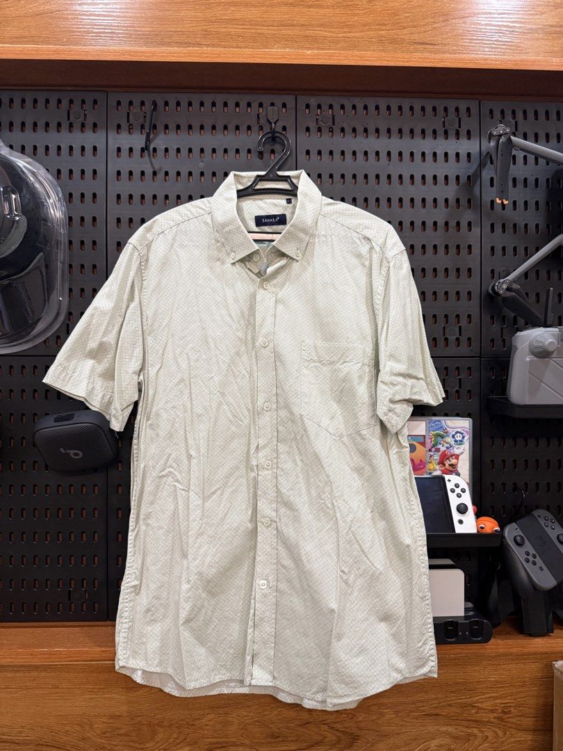 Sahara Short Sleeve Button Down Shirt (Category: Tshirts & Polo Shirts ) located in San Fernando. Submitted by archvst.selects (Listing ID 1463669102, Image 1). Description: - Sahara brand short sleeve button down shirt - Light beige color with subtle checkered pattern - Features a chest pocket - Classic collar design - Versatile for casual or smart-casual outfits - Easy to pair with shorts or pants Note: Item are personal preloved. Used once. Be