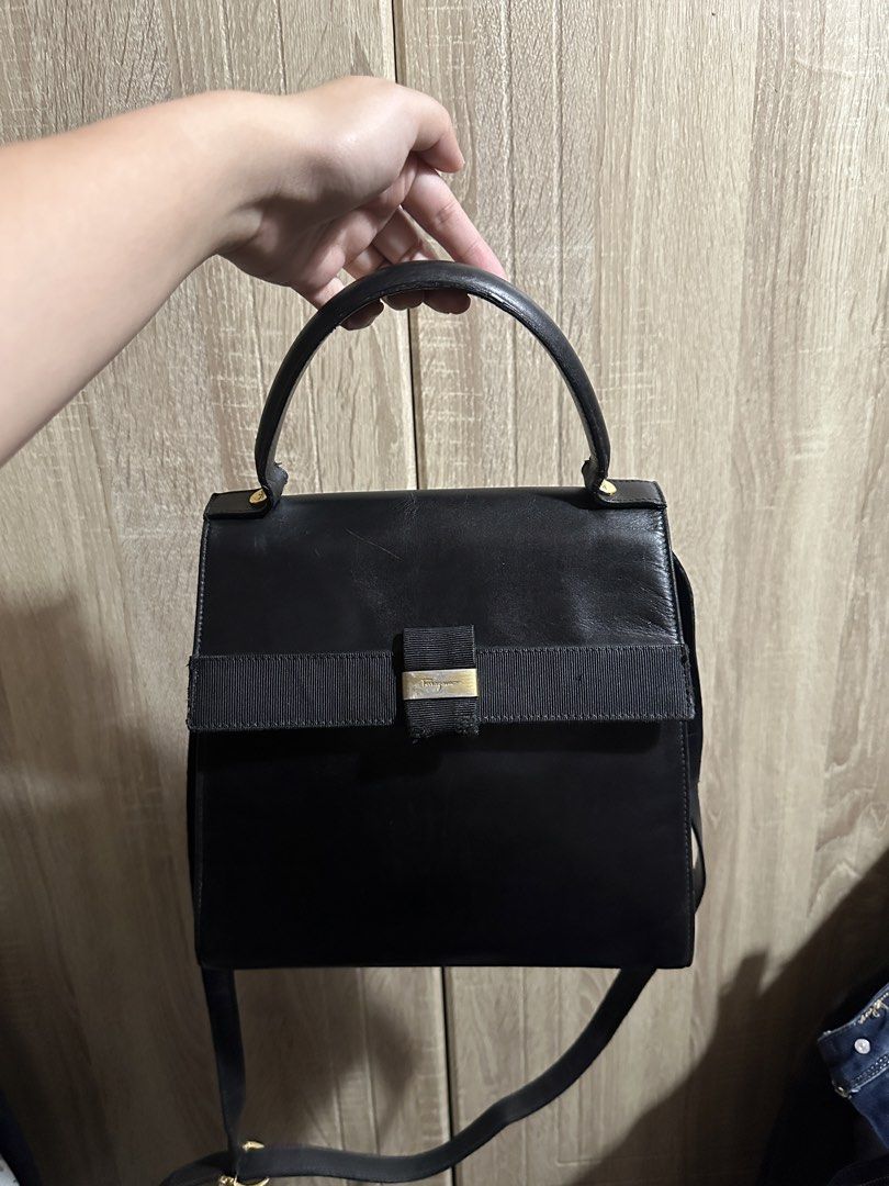 Salvatore Ferragamo Black Leather Top Handle Bag (Category: Luxury Bags & Wallets) located in Makati City. Submitted by love003xx (Listing ID 1463660709, Image 1). Description: - Classic black leather handbag by Salvatore Ferragamo - Features iconic ribbon detail with gold accent - Interior zip pocket for organization - Detachable strap for shoulder or crossbody wear - Made in Italy - Versatile for everyday use or special occasions.