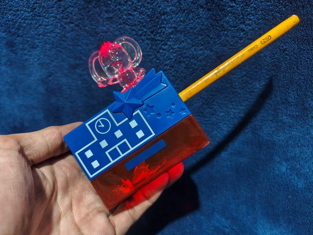 Sanrio Hello Kitty Pencil Sharpener with Toy Figure (Category: Stationery & School Supplies) located in Manila. Submitted by kirstentoyshub (Listing ID 1463660684, Image 1). Description: - Adorable Kitty pencil sharpener - Features a clear Kitty figure on top - Fun blue and red casing with star and clock designs - Convenient shavings compartment - Works with standard pencils - Ideal for Kitty fans, kids' stationery, or collectors.
