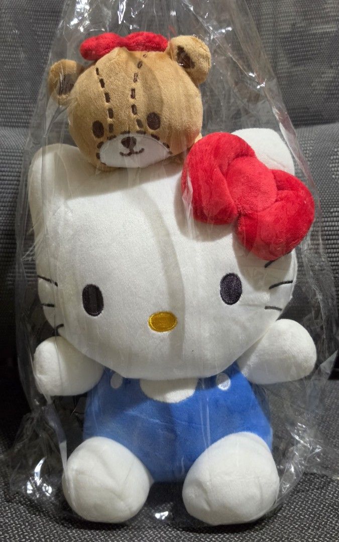 Sanrio Hello Kitty Plush Toy with Bear Charm (Category: Plushies & Soft Toys) located in Taytay. Submitted by king_ayamiku (Listing ID 1463715658, Image 1). Description: - Adorable Kitty plush toy - Features blue overalls and a cute bear charm on her head - Brand new, still in original packaging - Perfect for Kitty collectors and Sanrio fans - Great for display or as a thoughtful gift.
