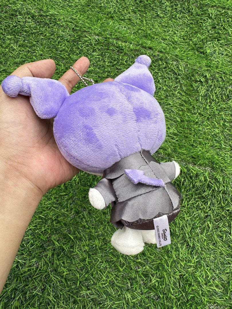 Sanrio Kuromi Plush Toy Keychain (Category: Plushies & Soft Toys) located in Manila. Submitted by ronoarabbit.ph (Listing ID 1463671215, Image 2). Description: - Winking Kuromi plush toy with a keychain attachment. - Features the cute purple character in a grey outfit. - Adorned with a pink bow and a black bow on its head with a pink heart accessory. - Ideal for decorating bags, backpacks, or as a fun collectible. - A must-have for any Sanrio fan