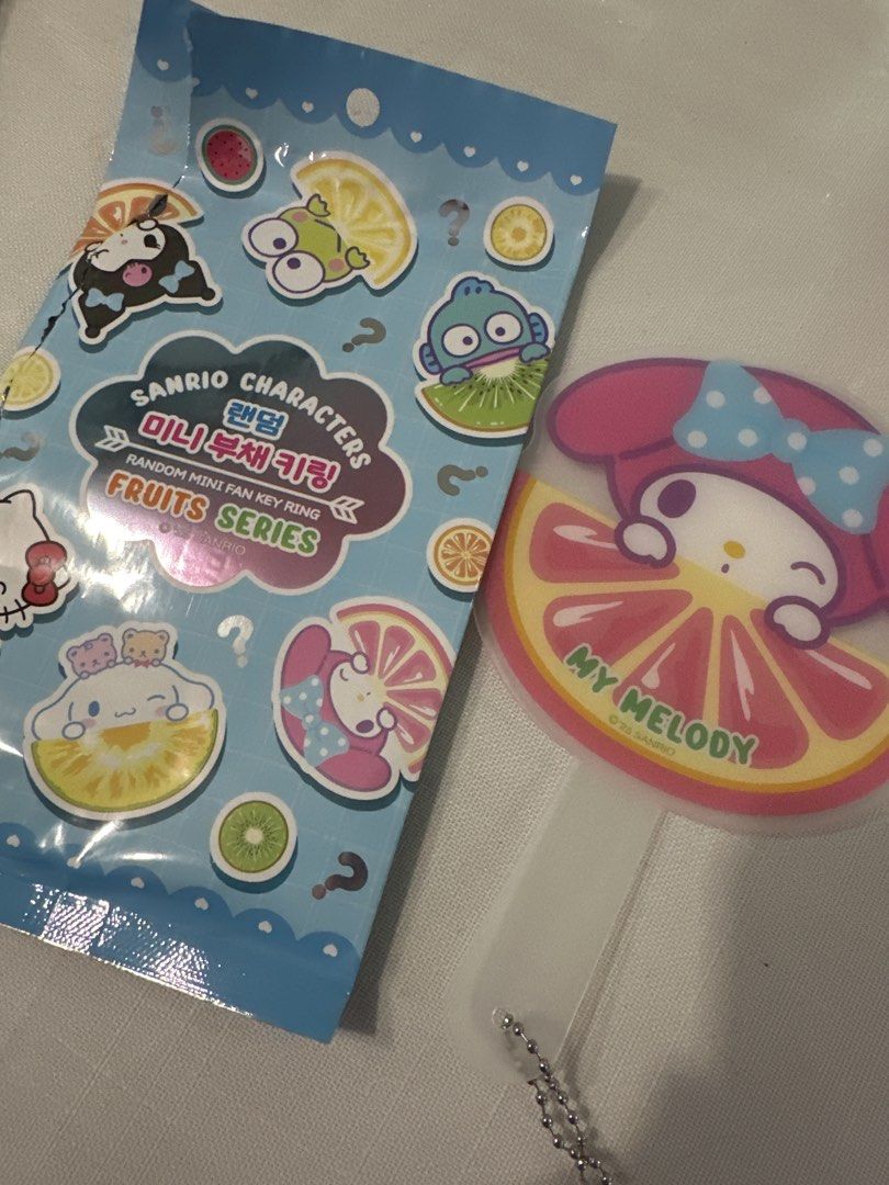 Sanrio Mini Fruit Series - Fan keyring (Category: Character Goods) located in Manila. Submitted by lunalux09 (Listing ID 1463579149, Image 3). Description: - Sanrio Characters Random Mini Fan Keychain - Fruits Series design - Features My Melody with a grapefruit motif - Perfect accessory for bags, backpacks, or keys - Comes with a small chain - Includes a cute lemon charm - Ideal gift for Sanrio collectors and fans.