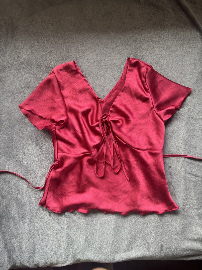Satin Tie Front Top (Category: Blouses) located in Manila. Submitted by _closetcleanup (Listing ID 1463578216, Image 1). Description: - Vibrant pinkish-red satin fabric - Flattering V-neckline - Adjustable tie-front detail - Cute short flutter sleeves - Slightly wavy hemline - Back ties for a customizable cinched waist - Perfect for dressing up or down.