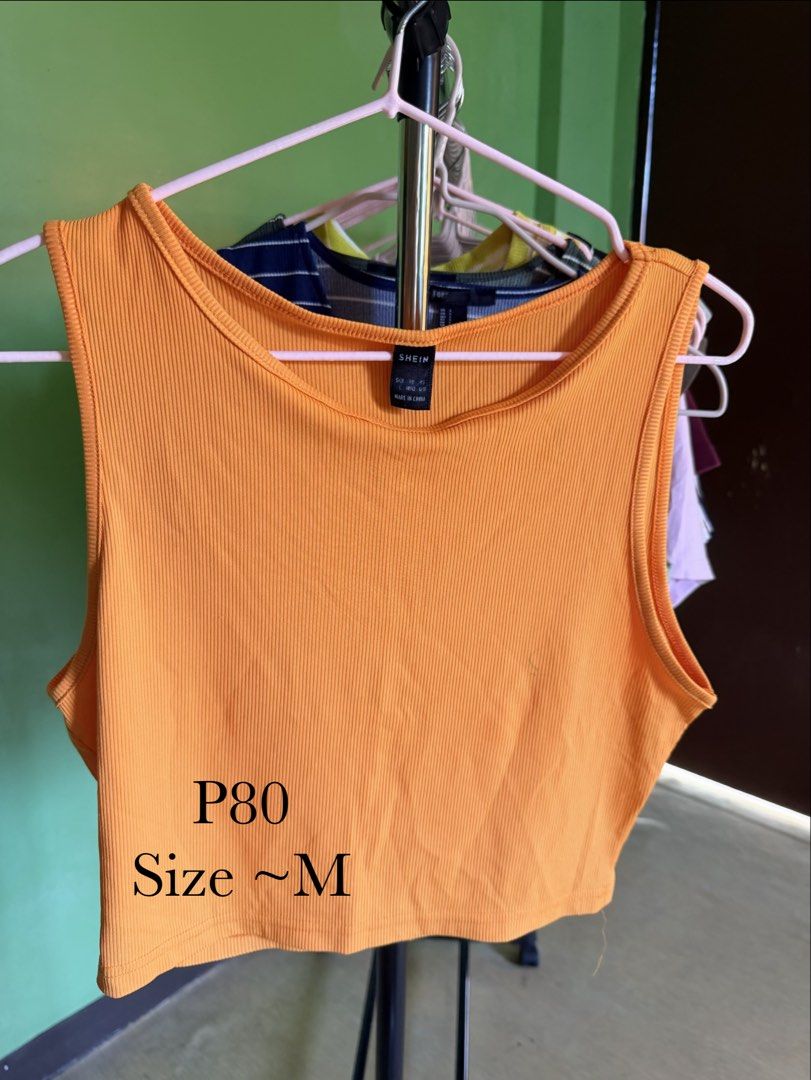 SHEIN Orange Ribbed Cropped Tank Top (Category: Sleeveless) located in Muntinlupa City. Submitted by cocofinds023 (Listing ID 1463711497, Image 1). Description: - Orange ribbed cropped tank top - Brand: SHEIN - Style: Sleeveless, round neckline - Material: Stretchy for comfort - Versatile: Great for casual wear or layering - Pairs well with shorts or skirts.