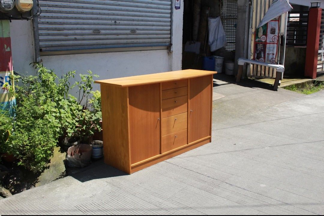 Sideboard Cabinet (Category: Shelves, Cabinets & Racks) located in Meycauayan. Submitted by marygracecasimiro (Listing ID 1463740868, Image 3). Description: Modern Wooden Sideboard Cabinet Five spacious drawers and two side cupboards with hinged doors. Finished in a warm honey-oak tone with sleek metallic knob pulls. Perfect for dining rooms, living rooms, entryways or additional home storage L:57 ¾ • W:19 • H:34 ¾ inches 11,500 pesos only💚 #hig