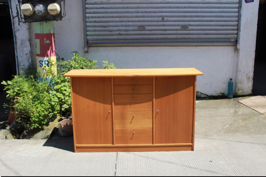 Sideboard Cabinet (Category: Shelves, Cabinets & Racks) located in Meycauayan. Submitted by marygracecasimiro (Listing ID 1463740868, Image 2). Description: Modern Wooden Sideboard Cabinet Five spacious drawers and two side cupboards with hinged doors. Finished in a warm honey-oak tone with sleek metallic knob pulls. Perfect for dining rooms, living rooms, entryways or additional home storage L:57 ¾ • W:19 • H:34 ¾ inches 11,500 pesos only💚 #hig