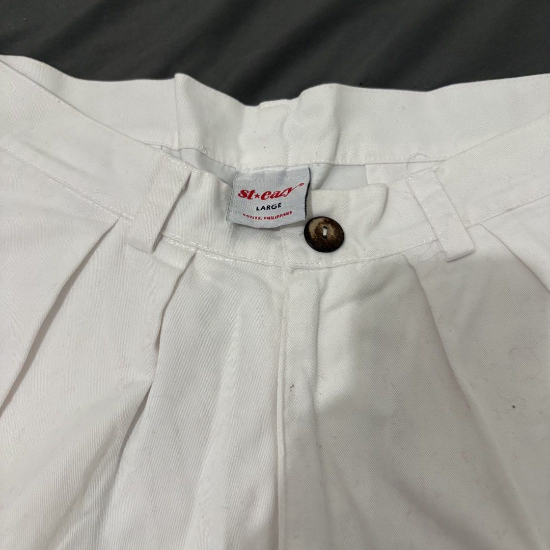 St. Eazy White Pleated Shorts Size L (Category: Shorts) located in Makati City. Submitted by sseurekiii (Listing ID 1463721178, Image 3). Description: - Brand: St. Easy - Color: White - Style: Pleated Shorts - Size: Large - Features: Embroidered St. Easy logo on left leg, two buttoned back pockets - Closure: Classic button and zip front - Occasion: Great for casual wear.