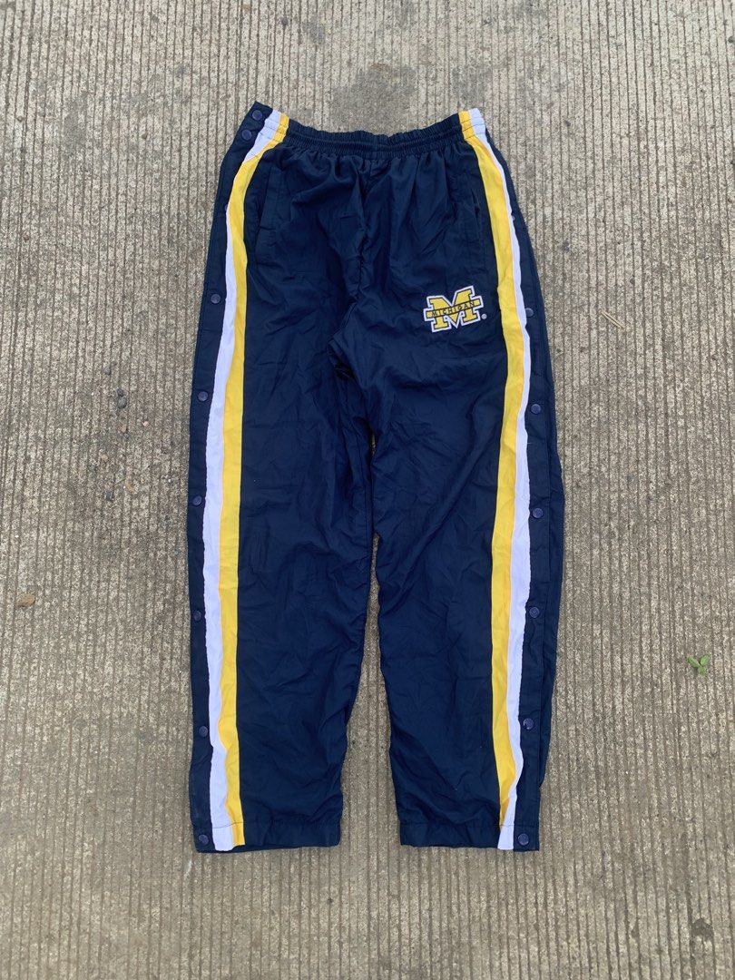 Starter Michigan Wolverines Snap Button Track Pants Navy Blue Yellow (Category: Joggers) located in Iloilo. Submitted by johnpullan30303 (Listing ID 1463691452, Image 2). Description: - Starter Navy Blue Track Pants - Features Michigan Wolverines logo on left leg - Yellow and white stripes down the sides - Full snap buttons on both legs for easy wear - Elastic waistband with drawstring - Size: Large (L).