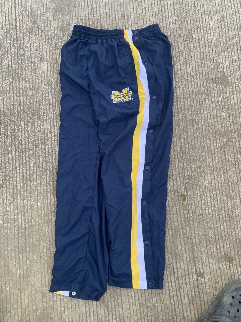 Starter Michigan Wolverines Snap Button Track Pants Navy Blue Yellow (Category: Joggers) located in Iloilo. Submitted by johnpullan30303 (Listing ID 1463691452, Image 3). Description: - Starter Navy Blue Track Pants - Features Michigan Wolverines logo on left leg - Yellow and white stripes down the sides - Full snap buttons on both legs for easy wear - Elastic waistband with drawstring - Size: Large (L).