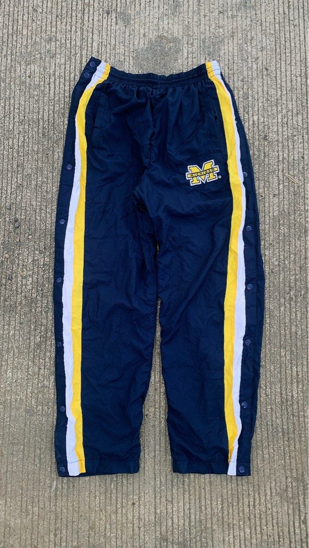 Starter Michigan Wolverines Snap Button Track Pants Navy Blue Yellow (Category: Joggers) located in Iloilo. Submitted by johnpullan30303 (Listing ID 1463691452, Image 1). Description: - Starter Navy Blue Track Pants - Features Michigan Wolverines logo on left leg - Yellow and white stripes down the sides - Full snap buttons on both legs for easy wear - Elastic waistband with drawstring - Size: Large (L).